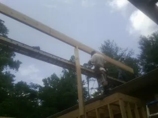Carpenter setting a ridge beam over a new addition frame — Ice Dam Removal by Roofing Brothers in Pearson