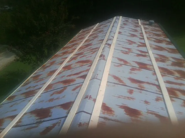 Rusted metal roof panels with new wood purlins before replacement — Storm Damage Roof Repair in Pearson by Roofing Brothers