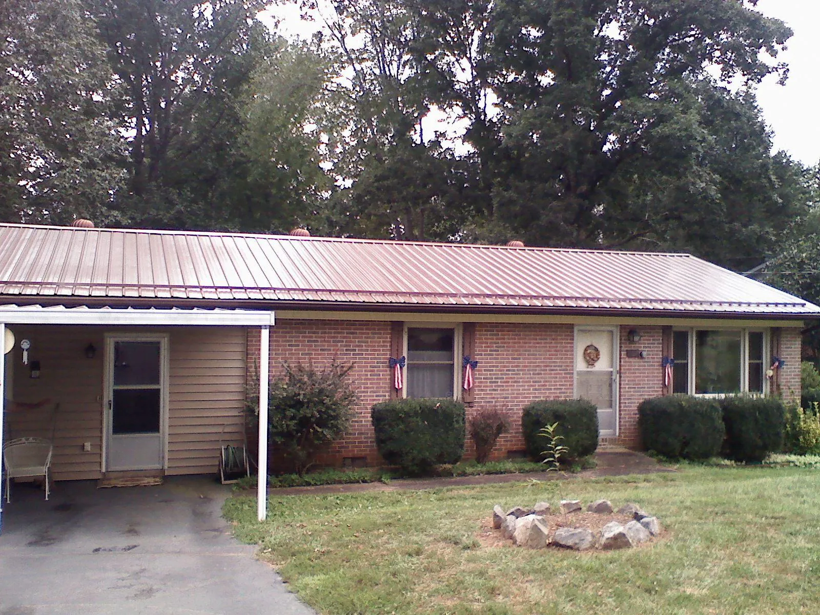 Bronze metal roof and carport on a brick ranch home — Roof Repair work by our crew in Pearson
